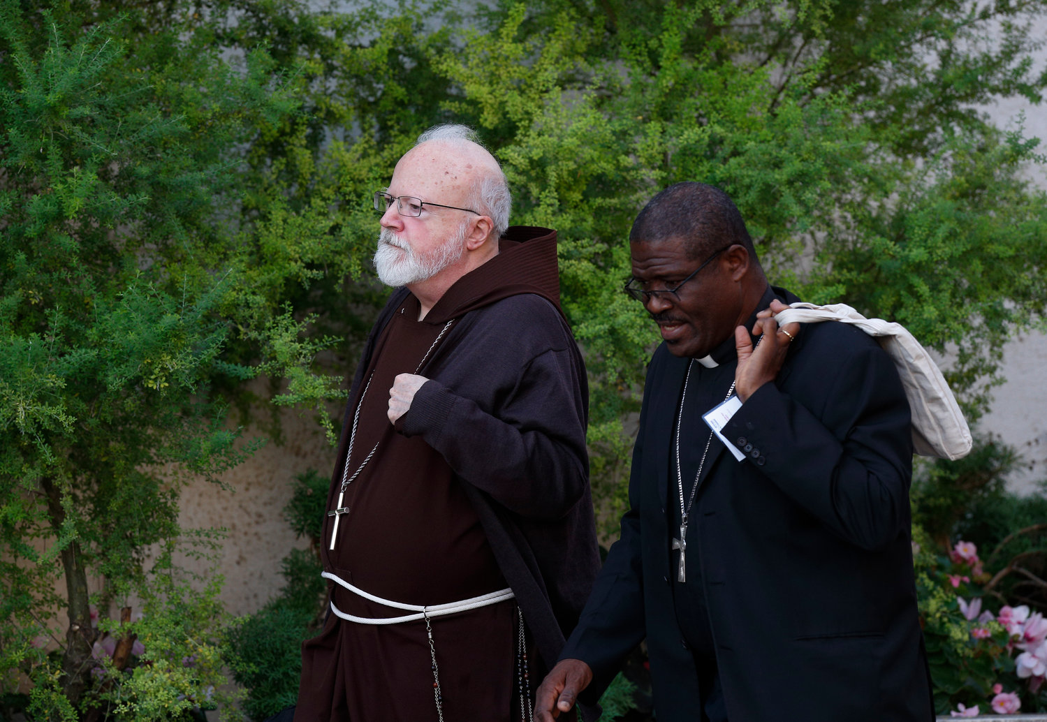 Cardinal Sean P. O’Malley of Boston and an unidentified priest arrive for a session of the Synod of Bishops for the Amazon at the Vatican Oct. 15, 2019.